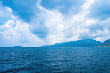 Panoramik sahil kıyısı Con Dao adası yukarıdan, dalgalar, kıyı şeridi, açık gökyüzü ve yol, mavi deniz ve dağ.