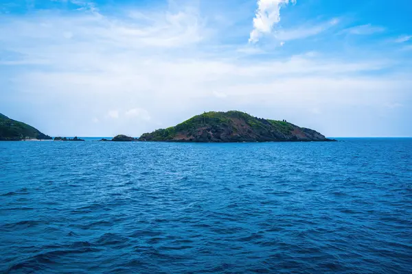 Panoramik sahil kıyısı Con Dao adası yukarıdan, dalgalar, kıyı şeridi, açık gökyüzü ve yol, mavi deniz ve dağ.