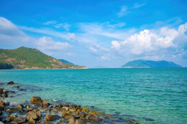 Panoramik sahil kıyısı Con Dao adası yukarıdan, dalgalar, kıyı şeridi, açık gökyüzü ve yol, mavi deniz ve dağ.