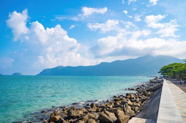 Panoramik sahil kıyısı Con Dao adası yukarıdan, dalgalar, kıyı şeridi, açık gökyüzü ve yol, mavi deniz ve dağ.