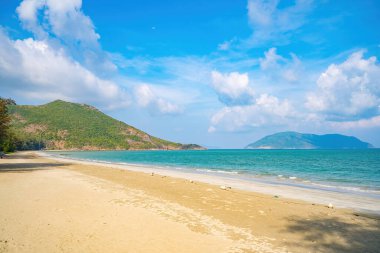 Panoramik sahil kıyısı Con Dao adası yukarıdan, dalgalar, kıyı şeridi, açık gökyüzü ve yol, mavi deniz ve dağ.
