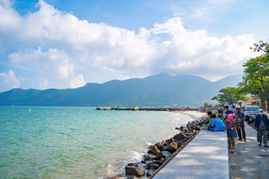Panoramik Con Dao adası manzaralı, dalgalar, kıyı şeridi, açık gökyüzü ve yol, mavi deniz ve dağ. Con Dao Adası 'ndaki Tarih Köprüsü 941.