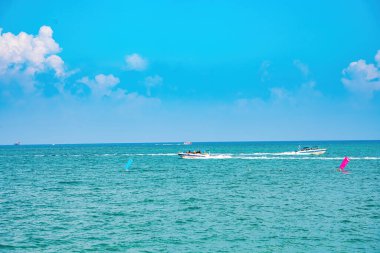 Beautiful cloudscape over the sea, sunrise shot. Lonely boats. Calm sea with sunset sky and sun through the clouds over. Calm sea with sunset sky or sunrise and sun through the clouds over.