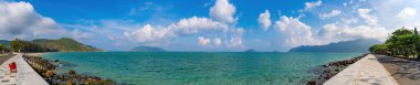 Panoramik sahil kıyısı Con Dao adası yukarıdan, dalgalar, kıyı şeridi, açık gökyüzü ve yol, mavi deniz ve dağ.