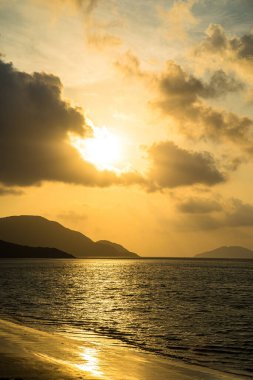 Calm sea with sunset sky and sun through the clouds over. Calm sea with sunset sky and sun through the clouds over. Meditation ocean and sky background. Tranquil seascape. Horizon over the water.