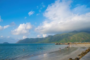 Panoramik sahil kıyısı Con Dao adası yukarıdan, dalgalar, kıyı şeridi, açık gökyüzü ve yol, mavi deniz ve dağ.