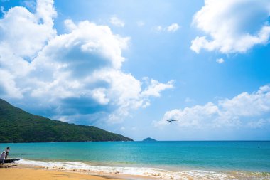 Con Dao adasındaki güzel Dam Trau plajı. Alt Manzara Uçağı iniyor. Mavi denizi ve dağıyla yukarıdan gelen vahşi sahil Con Dao adası, bir sürü bulut..