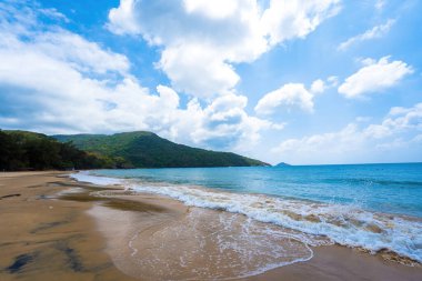 Con Dao adasındaki güzel Dam Trau plajı. Alt Manzara Uçağı iniyor. Mavi denizi ve dağıyla yukarıdan gelen vahşi sahil Con Dao adası, bir sürü bulut..
