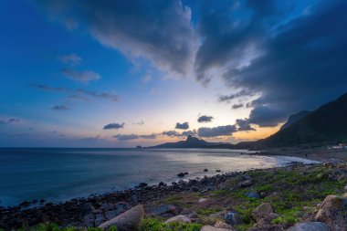 Panoramik Con Dao adası manzaralı, dalgalar, kıyı şeridi, açık gökyüzü ve yol, mavi deniz ve dağ. Bai Nhat Sahili 'nin havadan görünüşü ve sinematik gün batımı..