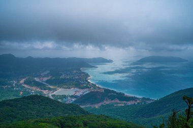 Panoramik kıyı kıyı şeridi Con Dao adası yukarıdan, dalgalar, kıyı şeridi, açık gökyüzü ve yol, mavi deniz ve dağ. Con Dao 'nun yeni yolcu portu.