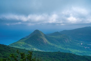 Panoramik kıyı kıyı şeridi Con Dao adası yukarıdan, dalgalar, kıyı şeridi, açık gökyüzü ve yol, mavi deniz ve dağ. Con Dao 'nun yeni yolcu portu.