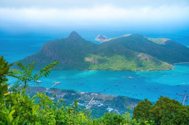 Panoramik kıyı kıyı şeridi Con Dao adası yukarıdan, dalgalar, kıyı şeridi, açık gökyüzü ve yol, mavi deniz ve dağ. Con Dao 'nun yeni yolcu portu.