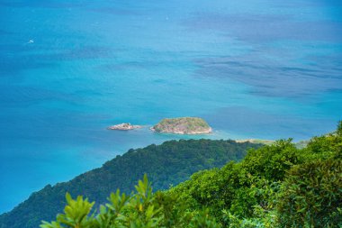 Panoramik kıyı kıyı şeridi Con Dao adası yukarıdan, dalgalar, kıyı şeridi, açık gökyüzü ve yol, mavi deniz ve dağ. Con Dao 'nun yeni yolcu portu.