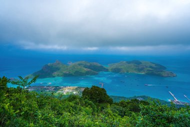 Panoramik kıyı kıyı şeridi Con Dao adası yukarıdan, dalgalar, kıyı şeridi, açık gökyüzü ve yol, mavi deniz ve dağ. Con Dao 'nun yeni yolcu portu.