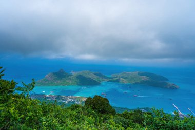 Panoramik kıyı kıyı şeridi Con Dao adası yukarıdan, dalgalar, kıyı şeridi, açık gökyüzü ve yol, mavi deniz ve dağ. Con Dao 'nun yeni yolcu portu.