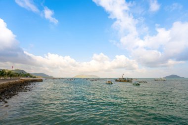 Güneş batarken sakin deniz Con Dao Adası üzerindeki bulutların arasından. Gün batımında gökyüzü ve bulutların arasında güneş olan sakin bir deniz. Meditasyon okyanusu ve gökyüzü arka planı. Huzurlu deniz manzarası.