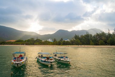 Güneş batarken sakin deniz Con Dao Adası üzerindeki bulutların arasından. Gün batımında gökyüzü ve bulutların arasında güneş olan sakin bir deniz. Meditasyon okyanusu ve gökyüzü arka planı. Huzurlu deniz manzarası.