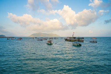 Güneş batarken sakin deniz Con Dao Adası üzerindeki bulutların arasından. Gün batımında gökyüzü ve bulutların arasında güneş olan sakin bir deniz. Meditasyon okyanusu ve gökyüzü arka planı. Huzurlu deniz manzarası.