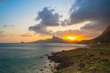Panoramik Con Dao adası manzaralı, dalgalar, kıyı şeridi, açık gökyüzü ve yol, mavi deniz ve dağ. Bai Nhat Sahili 'nin havadan görünüşü ve sinematik gün batımı..
