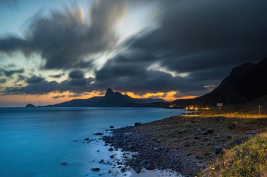 Panoramik Con Dao adası manzaralı, dalgalar, kıyı şeridi, açık gökyüzü ve yol, mavi deniz ve dağ. Bai Nhat Sahili 'nin havadan görünüşü ve sinematik gün batımı..