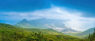 Panoramik kıyı kıyı şeridi Con Dao adası yukarıdan, dalgalar, kıyı şeridi, açık gökyüzü ve yol, mavi deniz ve dağ. Con Dao 'nun yeni yolcu portu.
