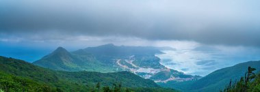 Panoramik kıyı kıyı şeridi Con Dao adası yukarıdan, dalgalar, kıyı şeridi, açık gökyüzü ve yol, mavi deniz ve dağ. Con Dao 'nun yeni yolcu portu.
