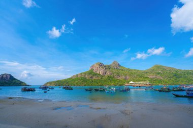 Panoramik Con Dao adası manzaralı, dalgalar, kıyı şeridi, açık gökyüzü ve yol, mavi deniz ve dağ. Bulutlu bir günde Bai Nhat plajının havadan görüntüsü. Seyahat kavramı
