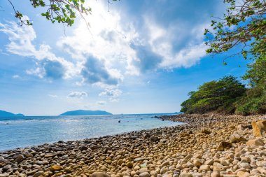 Panoramik Con Dao adası manzaralı, dalgalar, kıyı şeridi, açık gökyüzü ve yol, mavi deniz ve dağ. Bulutlu bir günde Bai Nhat plajının havadan görüntüsü. Seyahat kavramı