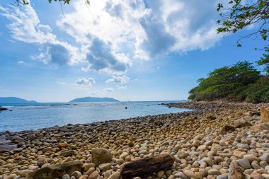Panoramik Con Dao adası manzaralı, dalgalar, kıyı şeridi, açık gökyüzü ve yol, mavi deniz ve dağ. Bulutlu bir günde Bai Nhat plajının havadan görüntüsü. Seyahat kavramı