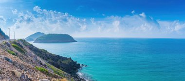 Panoramik Con Dao adası manzaralı, dalgalar, kıyı şeridi, açık gökyüzü ve yol, mavi deniz ve dağ. Bulutlu bir günde Bai Nhat plajının havadan görüntüsü. Seyahat kavramı