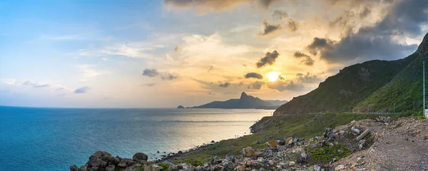 stock image Panoramic coastal Con Dao island view from above, with waves, coastline ,clear sky and road, blue sea and mountain. Aerial view of Bai Nhat beach with cinematic sunset.