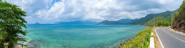 stock image Panoramic coastal Con Dao island view from above, with waves, coastline ,clear sky and road, blue sea and mountain.