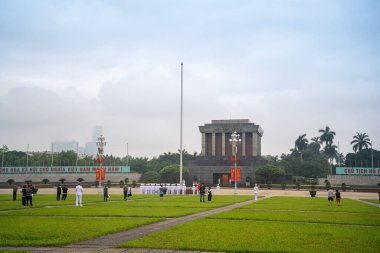 Ha Noi, VIETNAM - Mayıs 08 2023 The Ho Chi Minh Mausoleum Hanoi, Vietnam 'daki Ba Dinh Meydanı' nın merkezinde. Arka planda sinematik gökyüzü. Bayrak kaldırma etkinliği. Marş muhafızları