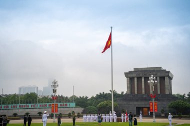 Ha Noi, VIETNAM - Mayıs 08 2023 The Ho Chi Minh Mausoleum Hanoi, Vietnam 'daki Ba Dinh Meydanı' nın merkezinde. Arka planda sinematik gökyüzü. Bayrak kaldırma etkinliği. Marş muhafızları