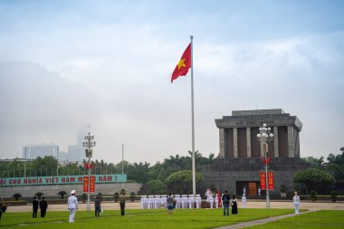 Ha Noi, VIETNAM - Mayıs 08 2023 The Ho Chi Minh Mausoleum Hanoi, Vietnam 'daki Ba Dinh Meydanı' nın merkezinde. Arka planda sinematik gökyüzü. Bayrak kaldırma etkinliği. Marş muhafızları