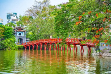 Ha Noi, VIETNAM - Mayıs 08 2023 - Hoan Kiem Gölü 'ndeki Huc Köprüsü, Vietnam' ın başkenti Hanoi 'nin tarihi merkezinde bulunan Hoan Kiem Gölü üzerindeki güzel Phoenix-Çiçeği.