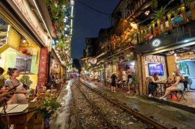 Hanoi, Vietnam - Mayıs 08 2023: Hanoi antik kasabasında demiryolu yakınında yaşayan insanların hayatı. Tren hattının yanındaki cadde Hanoi turistleri için ünlü bir yerdir.