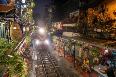 Hanoi, Vietnam - Mayıs 08 2023: Hanoi antik kasabasında demiryolu yakınında yaşayan insanların hayatı. Tren hattının yanındaki cadde Hanoi turistleri için ünlü bir yerdir.