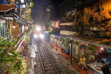 Hanoi, Vietnam - Mayıs 08 2023: Hanoi antik kasabasında demiryolu yakınında yaşayan insanların hayatı. Tren hattının yanındaki cadde Hanoi turistleri için ünlü bir yerdir.