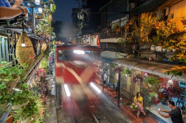 Hanoi, Vietnam - Mayıs 08 2023: Hanoi antik kasabasında demiryolu yakınında yaşayan insanların hayatı. Tren hattının yanındaki cadde Hanoi turistleri için ünlü bir yerdir.