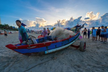 Vung Tau, VIETNAM - 14 Mayıs 2023: Balıkçı ağlarını gün doğumunda ya da günbatımında atıyor. Geleneksel balıkçılar balık ağını hazırlıyor.