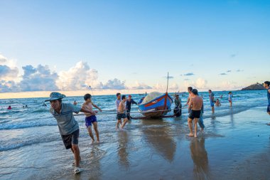 Vung Tau, VIETNAM - 14 Mayıs 2023: Balıkçı ağlarını gün doğumunda ya da günbatımında atıyor. Geleneksel balıkçılar balık ağını hazırlıyor.