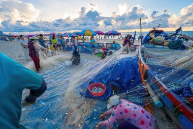 Vung Tau, VIETNAM - 14 Mayıs 2023: Balıkçı ağlarını gün doğumunda ya da günbatımında atıyor. Geleneksel balıkçılar balık ağını hazırlıyor.