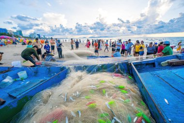 Vung Tau, VIETNAM - 14 Mayıs 2023: Balıkçı ağlarını gün doğumunda ya da günbatımında atıyor. Geleneksel balıkçılar balık ağını hazırlıyor.