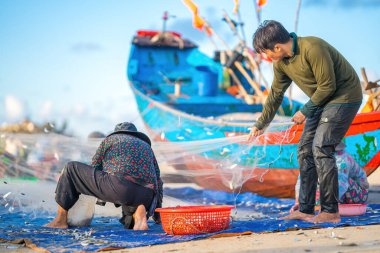 Balıkçı ağlarını gün doğumunda ya da günbatımında fırlatıyor. Geleneksel balıkçılar balık ağını hazırlıyor.