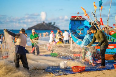 Vung Tau, VIETNAM - 14 Mayıs 2023: Balıkçı ağlarını gün doğumunda ya da günbatımında atıyor. Geleneksel balıkçılar balık ağını hazırlıyor.