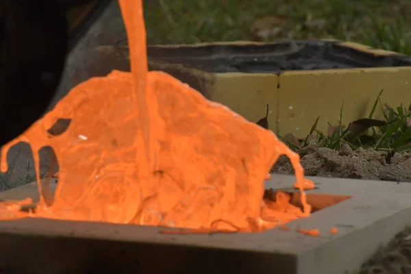 fire flame on a wooden log in the fireplace, background from melted iron