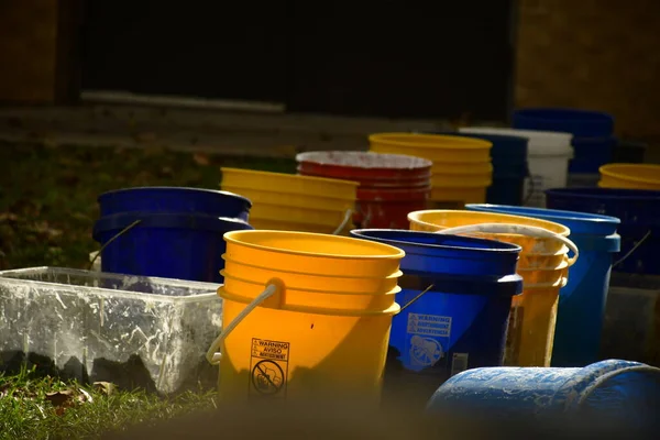 colorful plastic buckets in a row in the sunlight.