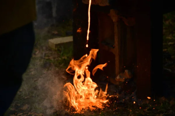 fire flame on a wooden log in the fireplace, background from melted iron