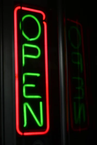 neon light of an open sign with a glowing led lamp on a black background.